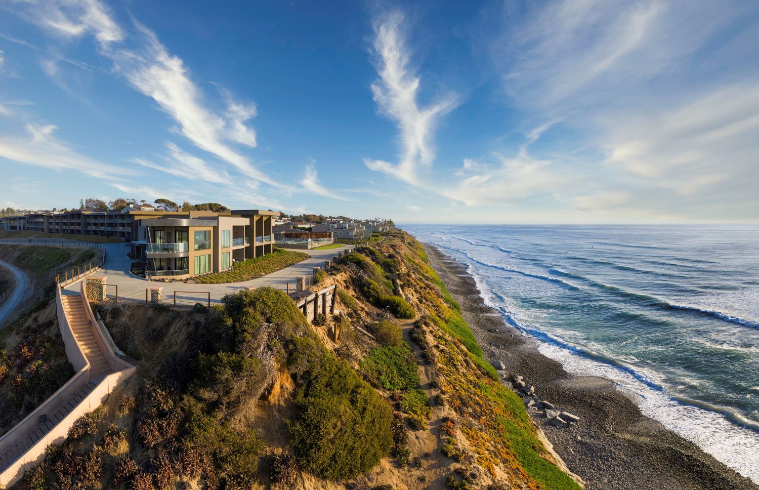The resort seen from above, following the curve of the coastal bluff down to the surf line